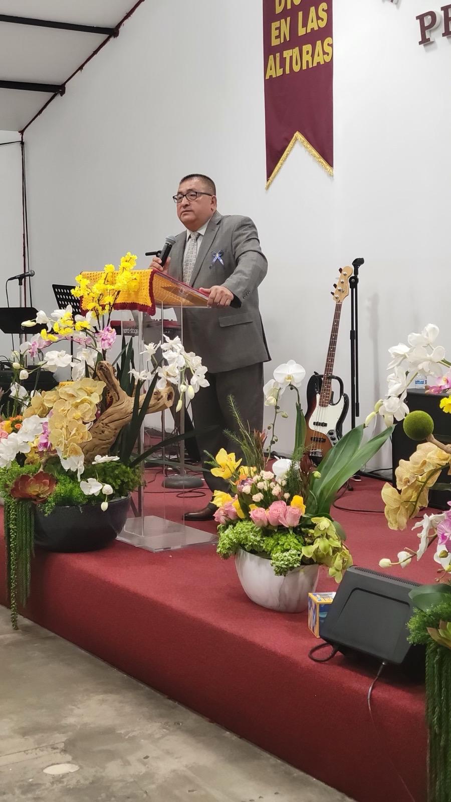 Pastor predicando con flores